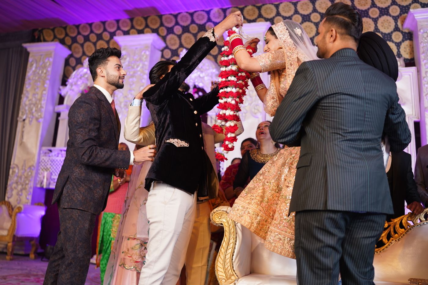 A bride and groom exchanging floral garlands during the jaimala