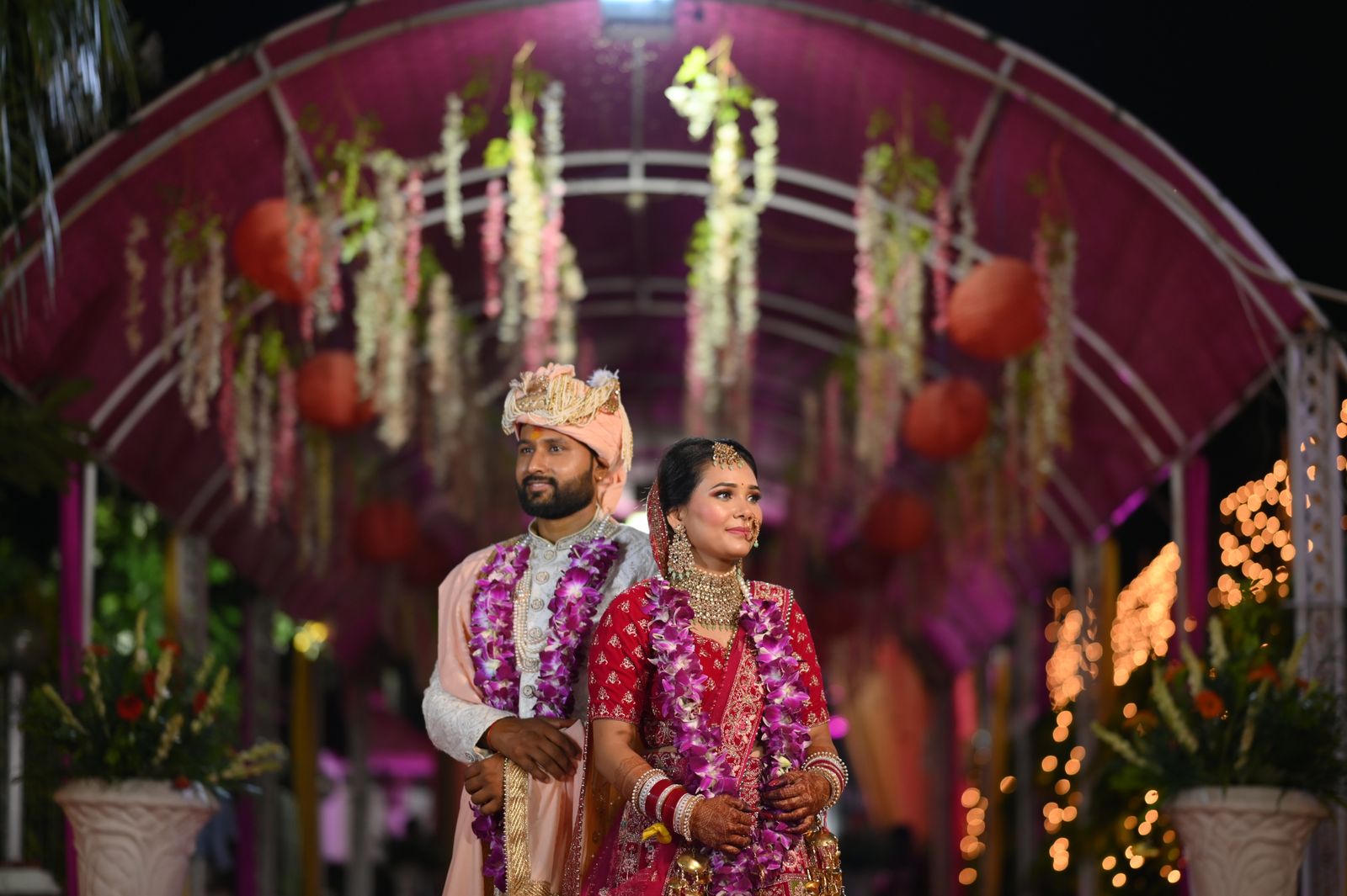 Newlyweds beneath a lit pavilion