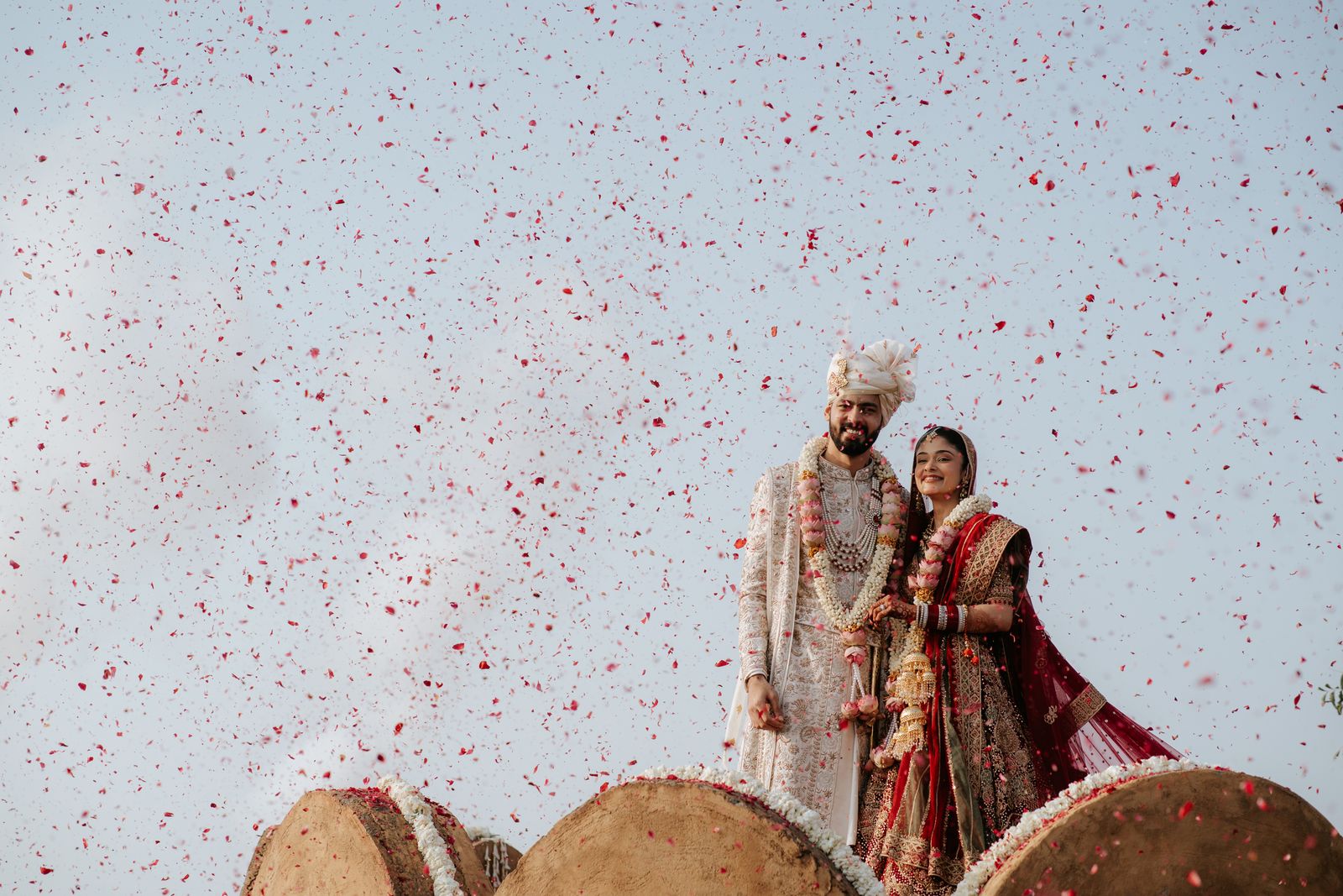 A couple beneath a shower of rose petals